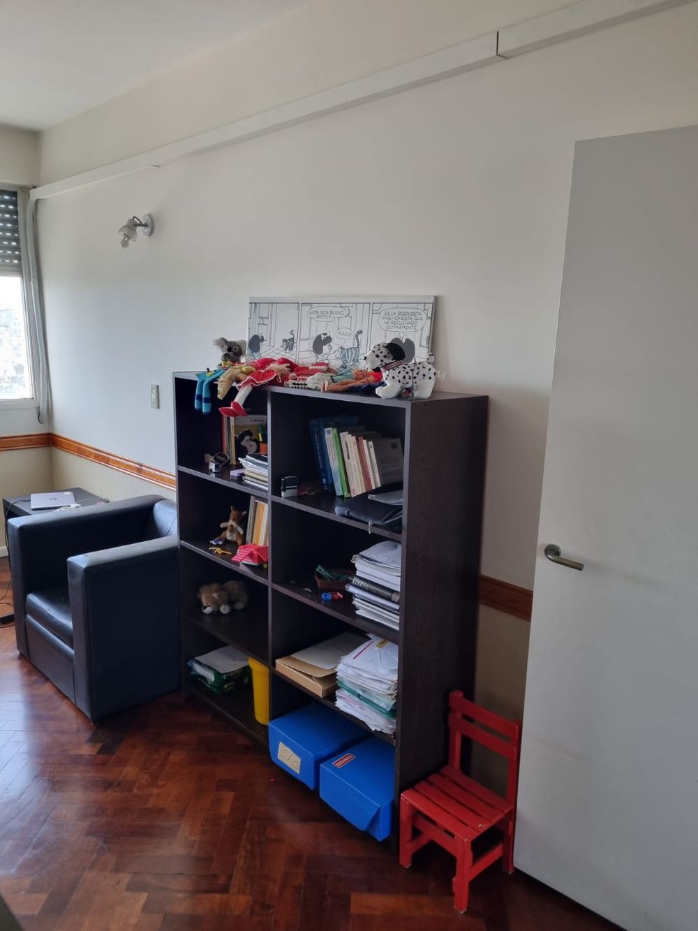 Biblioteca con libros y juegos para pacientes infantiles en el consultorio